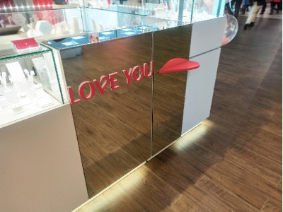 emphasis on the logo and a dispersed cash register area with a floating heart resembling a kiss